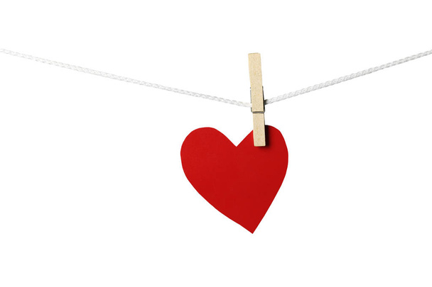 Червоні паперові серця висять на мотузці ізольовані на білому тлі і мають відсічні контури
. - Фото, зображення