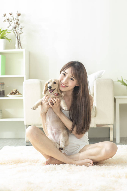 Portrait of Young woman with dog at home - Photo, image