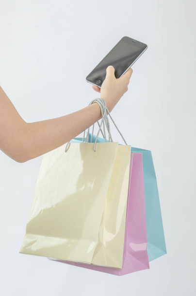 woman holding shopping bags and smartphone isolated on white background - Фото, зображення