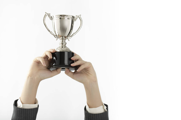 hands of businesswoman holding trophy cup isolated on white background - Foto, Imagem