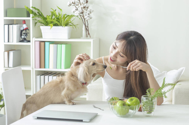 Portrait of Young woman with dog at home - Fotoğraf, Görsel