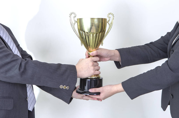 hands of businessmen holding trophy cup isolated on white background - 写真・画像