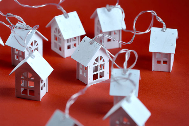 Toy houten huis garland op rode achtergrond - Foto, afbeelding