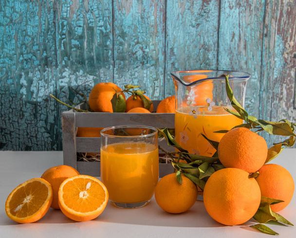 orange split in half with a glass and a jug of orange juice - Zdjęcie, obraz