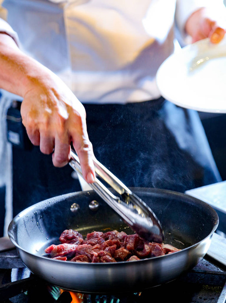 Cuoco che cucina cibo in cucina, Cuoco che prepara cibo, cibo che frigge nella padella del wok
 - Foto, immagini