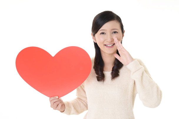 Усміхнена жінка тримає символ рожевого серця любові
 - Фото, зображення