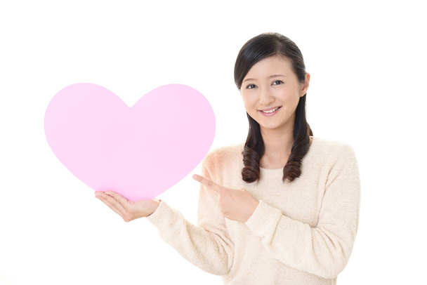 Usmívající se žena hospodářství růžové srdce láskou symbolu - Fotografie, Obrázek
