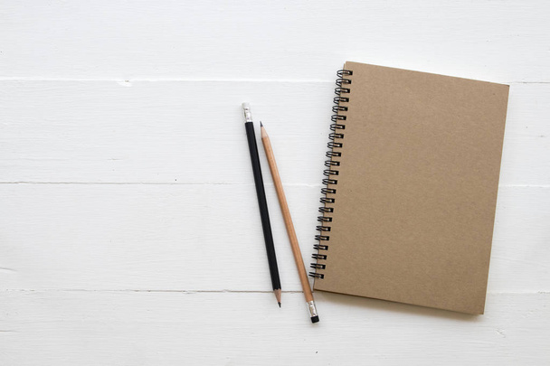 Notebook, ołówek student piśmie Uwaga dla badania dekoracji płaskie leżał stylu na białym tle drewnianych - Zdjęcie, obraz