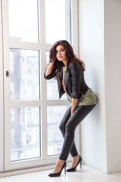 Lovely brunette woman wearing stylish clothes posing at luxury apartment interior - 写真・画像