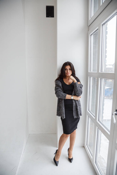 Lovely brunette woman wearing stylish clothes posing at luxury apartment interior - Foto, Imagem
