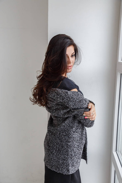 Lovely brunette woman wearing stylish clothes posing at luxury apartment interior - 写真・画像