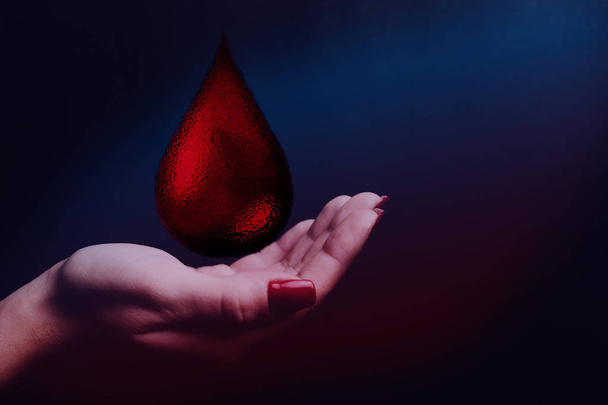 De daling van de bloed van menselijke hand. De stof van de nevel in de oneindige ruimte. Blood Donor Werelddag. Mixed media. - Foto, afbeelding