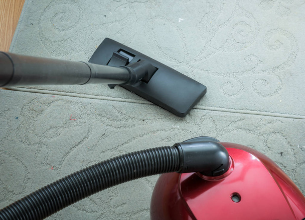 Vacuum cleaner on a gray carpet. Housework - Photo, Image