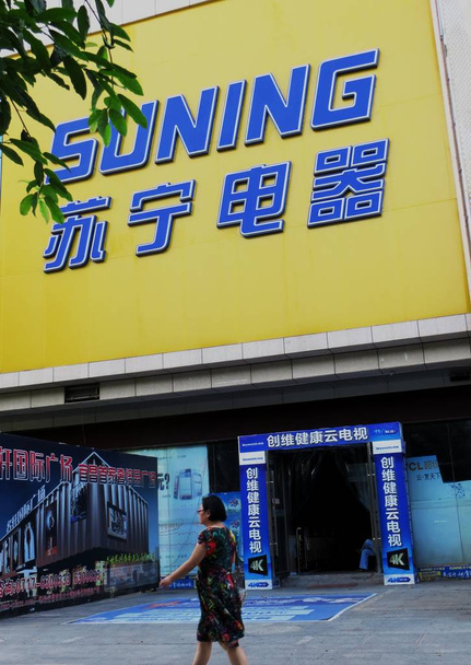 Ένας πεζός περπατάει μετά από μια διαφήμιση συσκευών Suning στο Yichang, Κέντρο Chinas Hubei, 10 Ιουλίου 2013 - Φωτογραφία, εικόνα