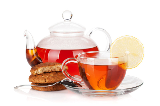 Стеклянная чашка и чайник черного чая с лимоном и печеньем
 - Фото, изображение
