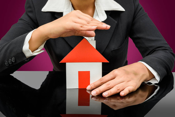 Business woman holding a model house. Home insurance concept - Zdjęcie, obraz