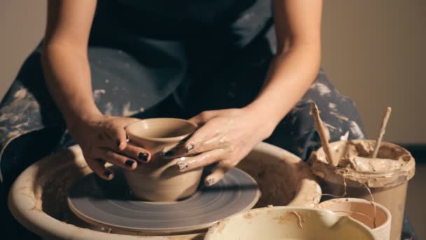 Woman girl her hands dub wall jug, sculpts out of clay on circle. - Footage, Video