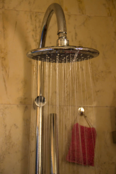 Salle de douche tons bruns, l'eau coule de la douche ronde
 - Photo, image