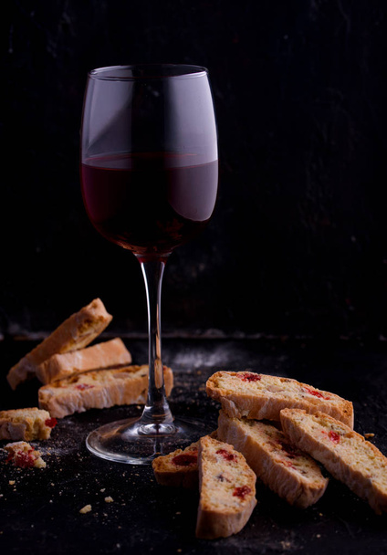 Delicious biscotti cookies with dried cherries and hazelnuts. Organic style. A glass of red wine. - Foto, imagen