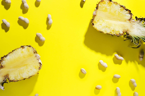 Vista superior de abacaxi e amendoim com longas sombras sobre fundo amarelo brilhante, espaço vazio para texto
 - Foto, Imagem