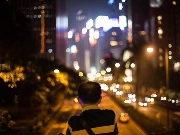 Мужчина смотрит на ночной пейзаж в Ван Чае, Гонконг, Китай, 24 сентября 2014 г.
 - Фото, изображение