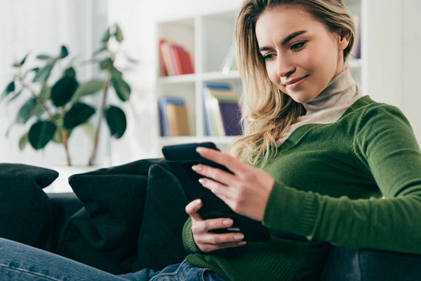 Gelukkige vrouw studie met ebook zittend op de Bank thuis - Foto, afbeelding