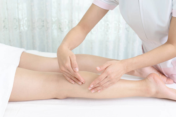 Frau mit entspannender Massage am Bein im Wellness-Salon  - Foto, Bild