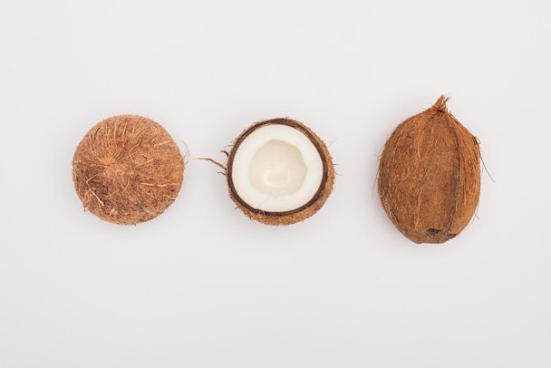 top view of whole coconut and coconut halves on grey background - Φωτογραφία, εικόνα
