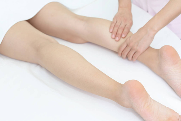 woman having relaxing massage on her leg in spa salon  - Фото, изображение
