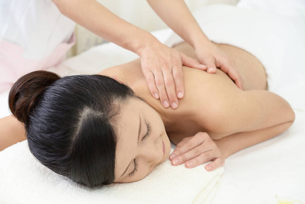 Hermosa mujer disfrutando de un masaje en un centro de spa
 - Foto, Imagen