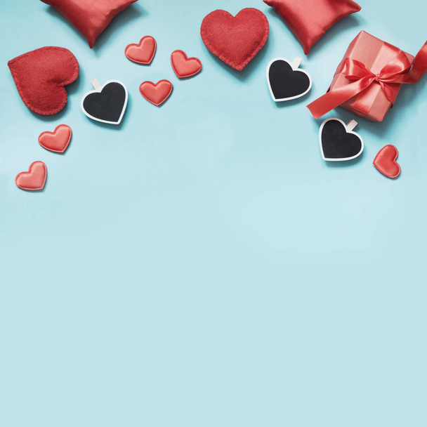 Valentine's day card. Composition with gifts, red hearts on blue surface. Top view. Space for text. - Foto, Imagem