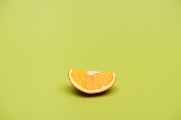 Slice of fresh ripe juicy orange on green background - Фото, изображение