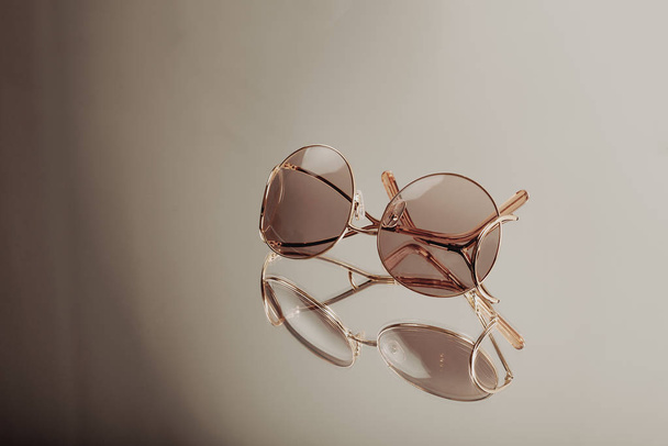 Glasses Elite Sunglasses in a modern fashionable golden metal frame on a silver background - Valokuva, kuva