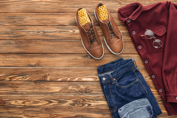 Flat lay with boots, shirt and jeans on wooden background - Foto, Imagen