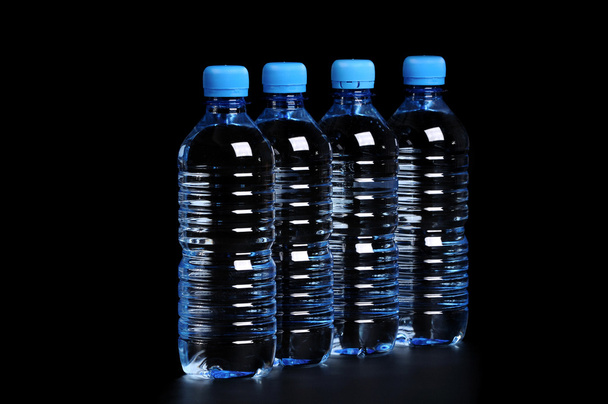 Bottled water isolated over a black background - Valokuva, kuva