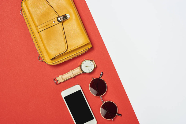Vue du dessus du sac jaune, lunettes de soleil, smartphone, montre avec espace de copie
  - Photo, image