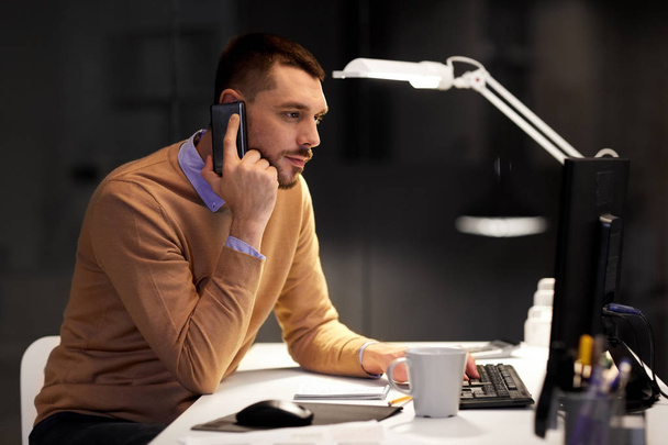businessman calling on sartphone at night office - Foto, Bild