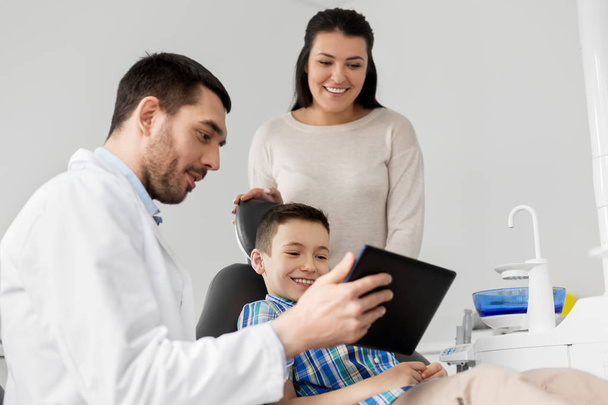 dentist showing tablet pc to kid at dental clinic - Фото, зображення