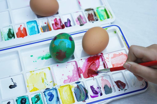 Activité de peinture d'oeufs de Pâques colorés avec fond de plateau de couleur, événement amusant pour concept enfant, espace de copie
 - Photo, image