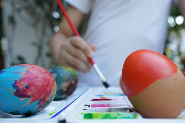 Colorida actividad de pintura de huevos de Pascua con fondo de bandeja de color, evento divertido para el concepto de niño, espacio de copia
 - Foto, Imagen