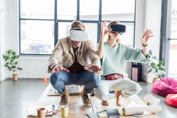 збуджена жінка і чоловік архітектори жестикулюють руками, маючи досвід віртуальної реальності в офісі лофт
 - Фото, зображення