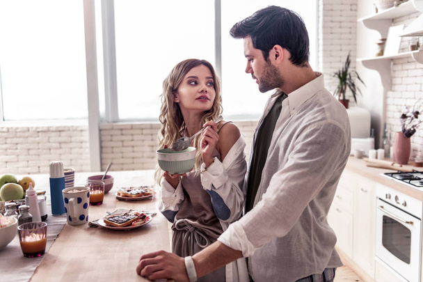 Pretty long-haired young woman in a white shirt and her husband enjoying breakfast - Foto, Imagem