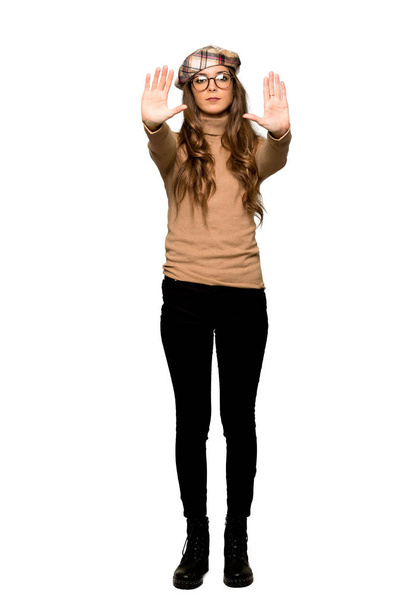 Tiro de comprimento total de mulher jovem com boina fazendo gesto de parada para decepcionado com uma opinião sobre fundo branco isolado
 - Foto, Imagem