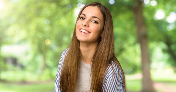 Young girl with striped shirt keeping the arms crossed while smiling at outdoors - Photo, Image