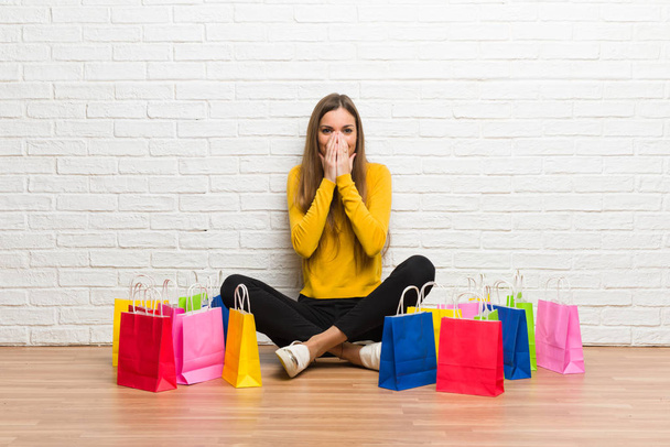 Young girl with lot of shopping bags smiling a lot while covering mouth - Photo, Image