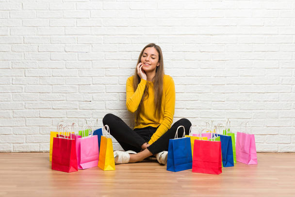 Young girl with lot of shopping bags with toothache - Foto, Imagen