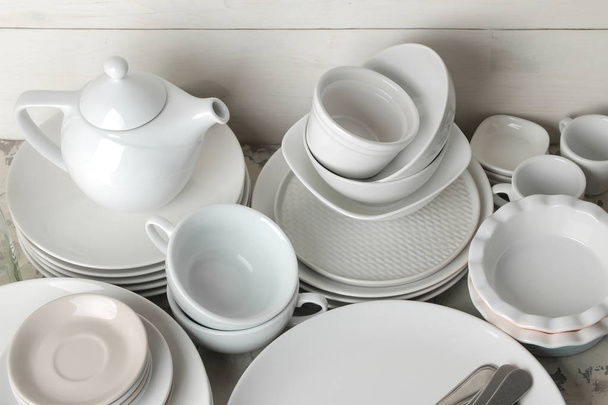 a lot of different dishes. Dinnerware. on a light concrete background. dishes for serving the table. various plates, bowls, and cups. - Photo, Image