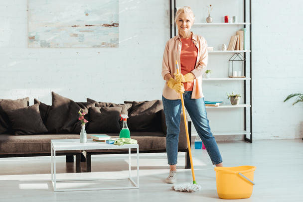 Smiling senior woman posing with mop and bucket - Photo, Image