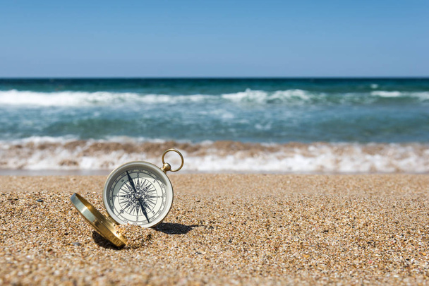 kompas na złotym piasku nad morzem - Zdjęcie, obraz