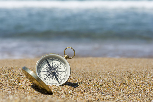 kompas na złotym piasku nad morzem - Zdjęcie, obraz
